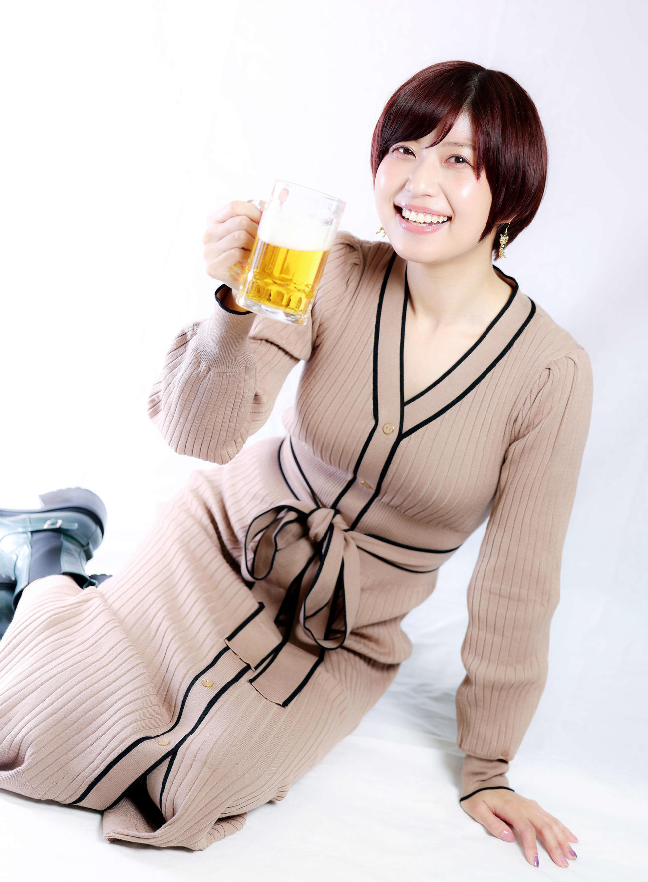 ビールを飲みながら満足そうな笑顔を見せる天野麻菜＝2022年11月