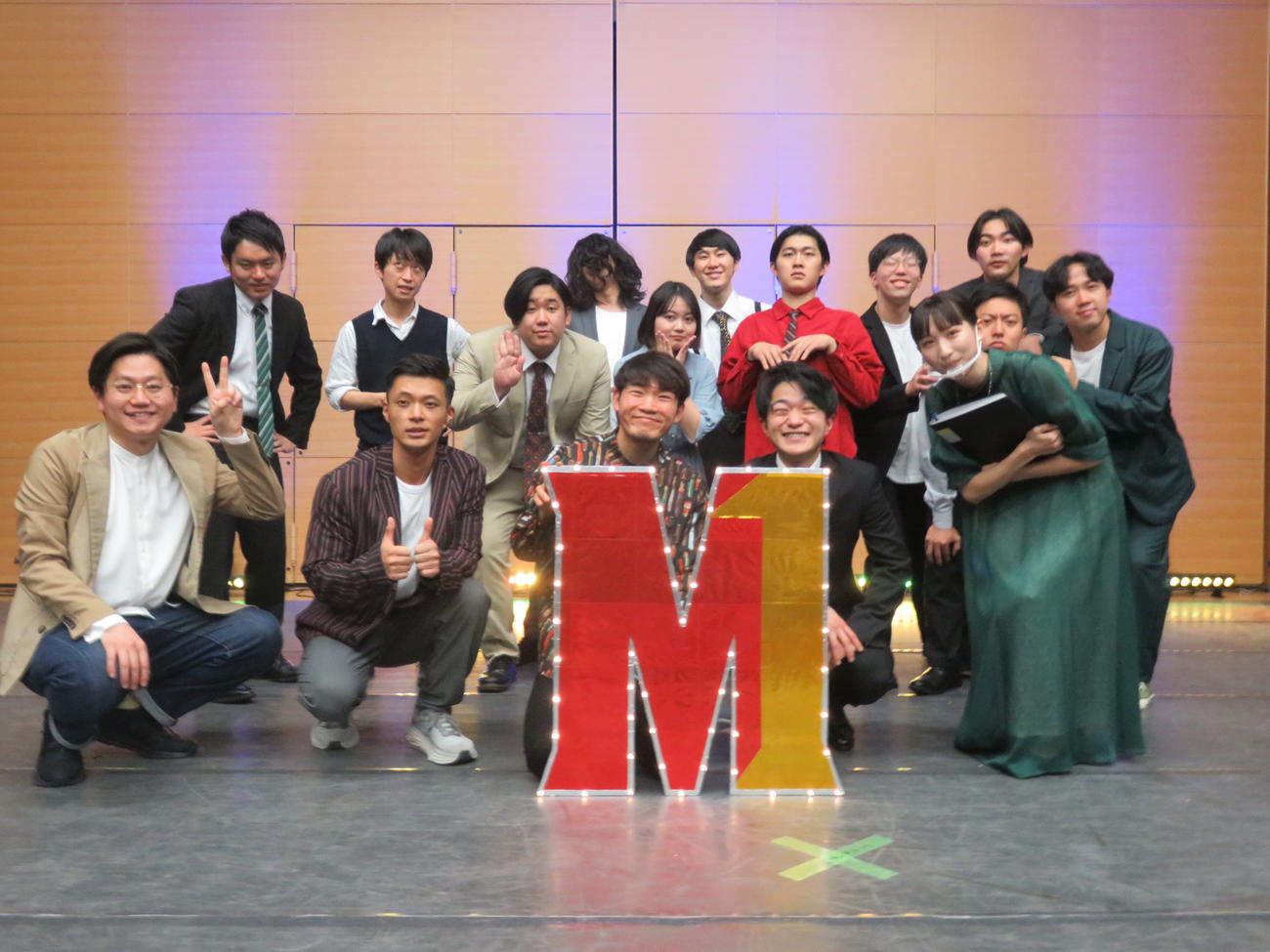 「大学生M－1グランプリ2022」の決勝出演者たち。前列左からゲストMC東京ホテイソンのたける、ショーゴ、優勝したもぐら大戦争の加藤大戦争、バクダン
