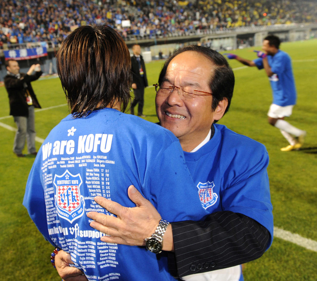 J1昇格が決まり、選手と抱き合って喜ぶ甲府の海野一幸社長（右）（2010年11月14日撮影）
