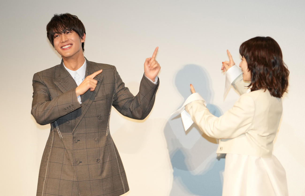 映画「スクロール」完成披露舞台あいさつでスクリーンを指さす中川大志（左）と松岡茉優（撮影・鈴木みどり）