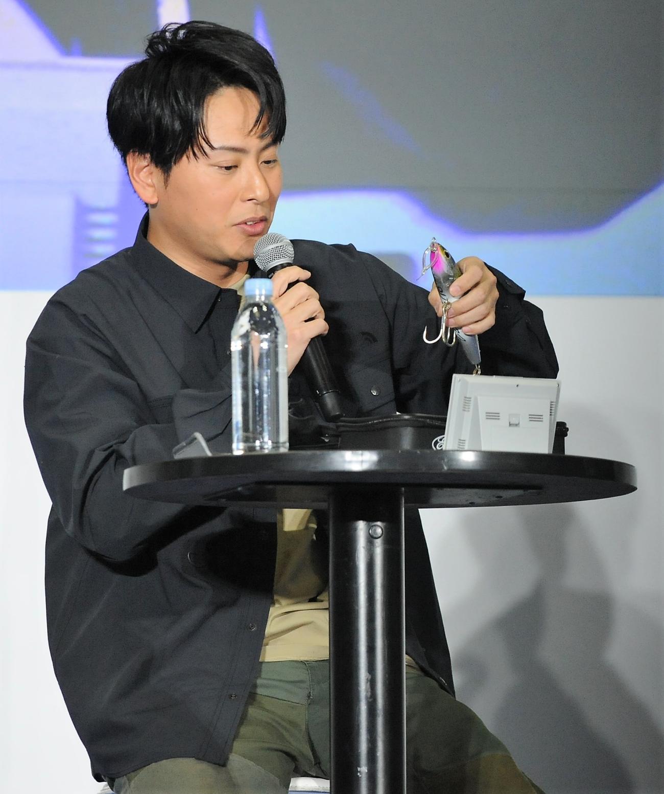 「釣りフェスティバル2023 in Yokohama」に出席し、ルアーを見つめる山下健二郎
