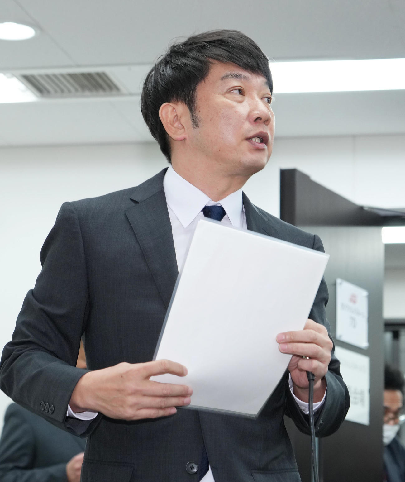 資料を手に会見場に入るTKO木本武宏（撮影・菅敏）