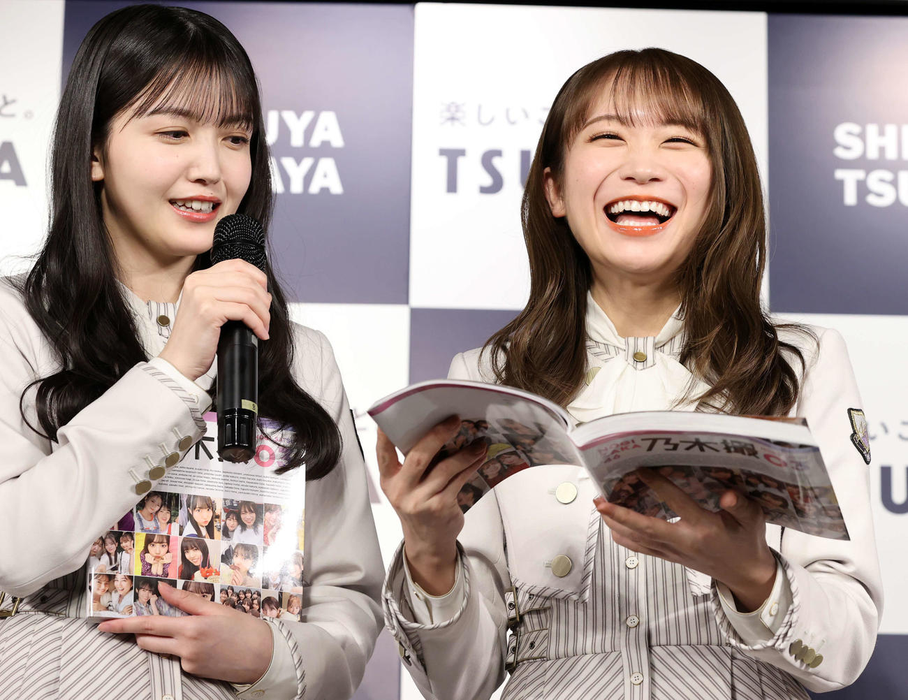 乃木坂46写真集「乃木撮　VOL．03」刊行記念会見で、写真集を手に笑顔の秋元真夏（右）。左は久保史緒里（撮影・浅見桂子）