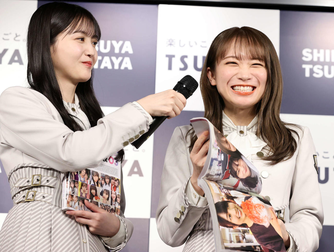 乃木坂46写真集「乃木撮　VOL．03」刊行記念会見で、写真集を手に笑顔の秋元真夏（右）。左は久保史緒里（撮影・浅見桂子）