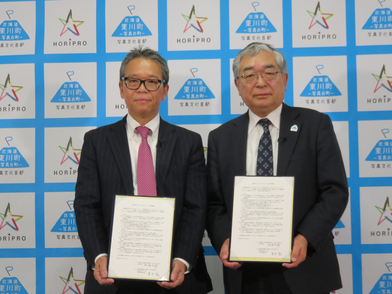オフィシャルパートナー協定を結んだ海道・東川町の松岡市郎町長（右）とホリプロ菅井敦社長