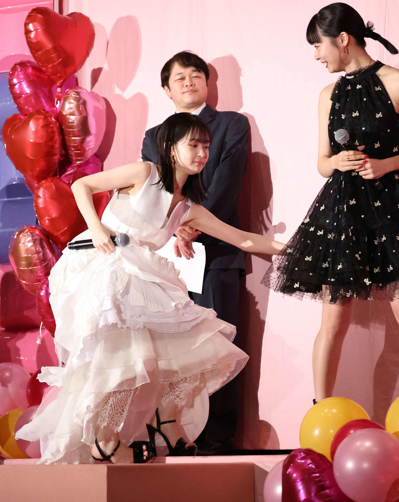 白いドレスに高いヒールで登壇し、よろける畑芽育。右は莉子（撮影・丹羽敏通）