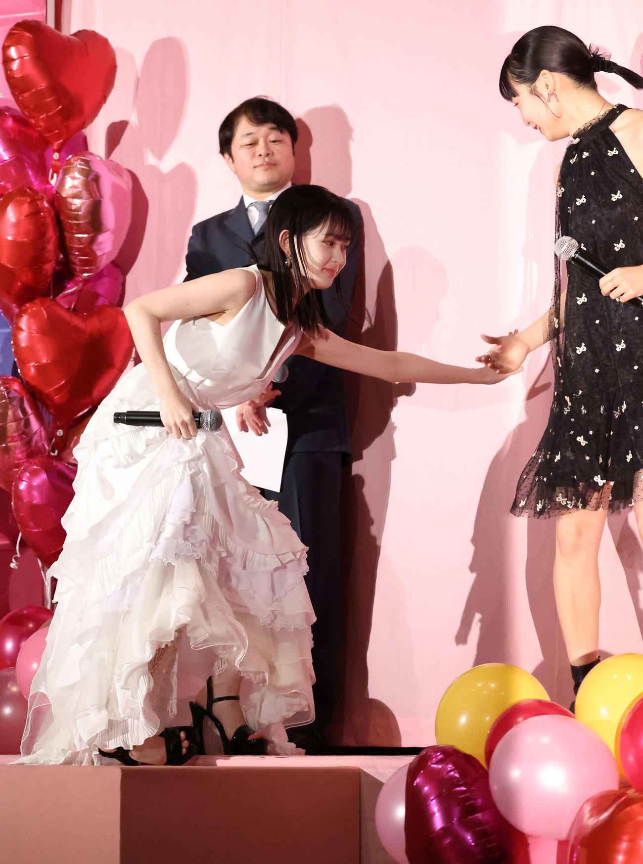 白いドレスに高いヒールで登壇し、よろける畑芽育（左）。右は莉子（撮影・丹羽敏通）