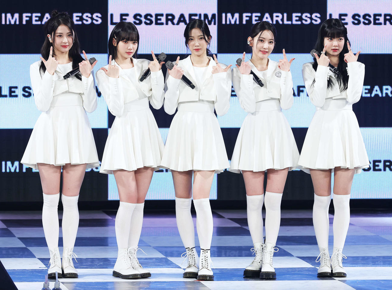 フォトセッションでポーズを決め写真に納まるLE SSERAFIMの、左からHUH YUNJIN、KIM CHAEWON、KAZUHA、SAKURA、HONG EUNCHAE（撮影・河田真司）