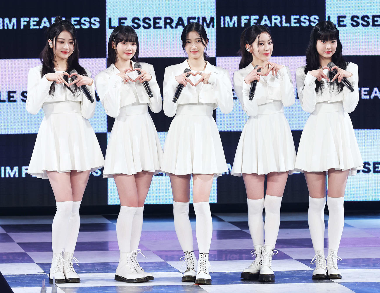 フォトセッションでポーズを決め写真に納まるLE SSERAFIMの、左からHUH YUNJIN、KIM CHAEWON、KAZUHA、SAKURA、HONG EUNCHAE（撮影・河田真司）