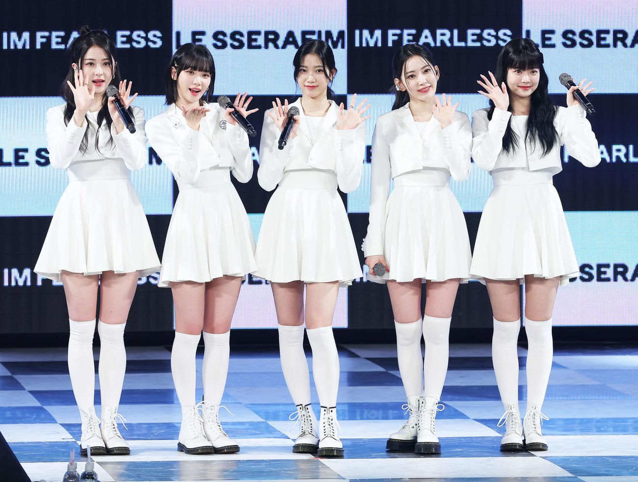 フォトセッションでポーズを決め写真に納まるLE SSERAFIMの、左からHUH YUNJIN、KIM CHAEWON、KAZUHA、SAKURA、HONG EUNCHAE（撮影・河田真司）