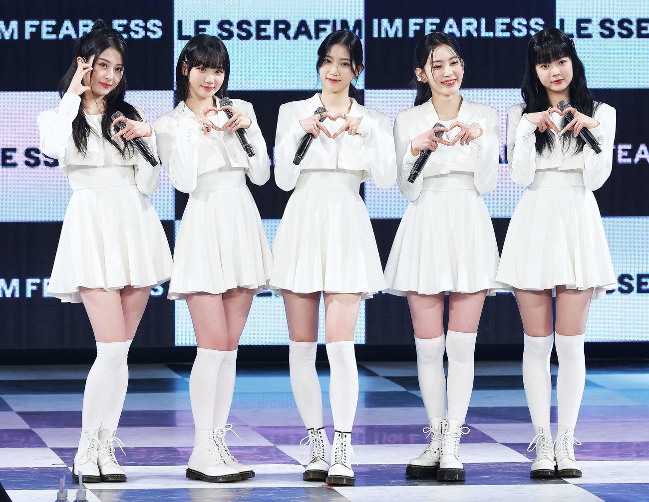 フォトセッションでポーズを決め写真に納まるLE SSERAFIMの、左からHUH YUNJIN、KIM CHAEWON、KAZUHA、SAKURA、HONG EUNCHAE（撮影・河田真司）