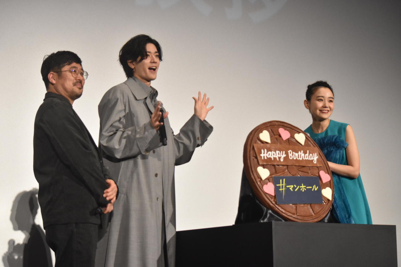 主演映画「＃マンホール」前夜祭舞台あいさつに登壇したサプライズで奈緒（右）に誕生日ケーキをプレゼントする中島裕翔（中央）。左は熊切監督