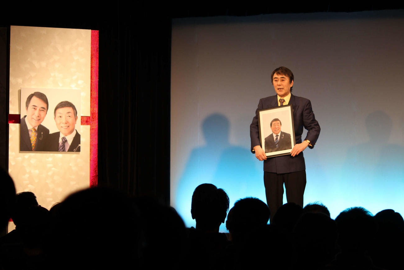 亡き兄の写真を手に思い出を語る酒井とおる