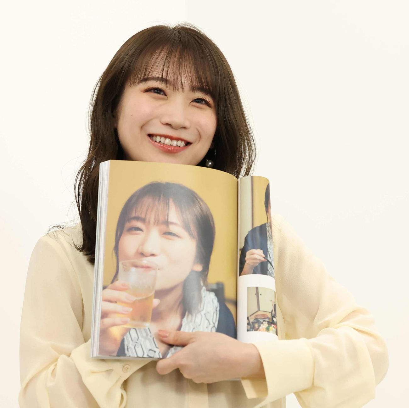 お気に入りのカットを示す秋元真夏（撮影・丹羽敏通）