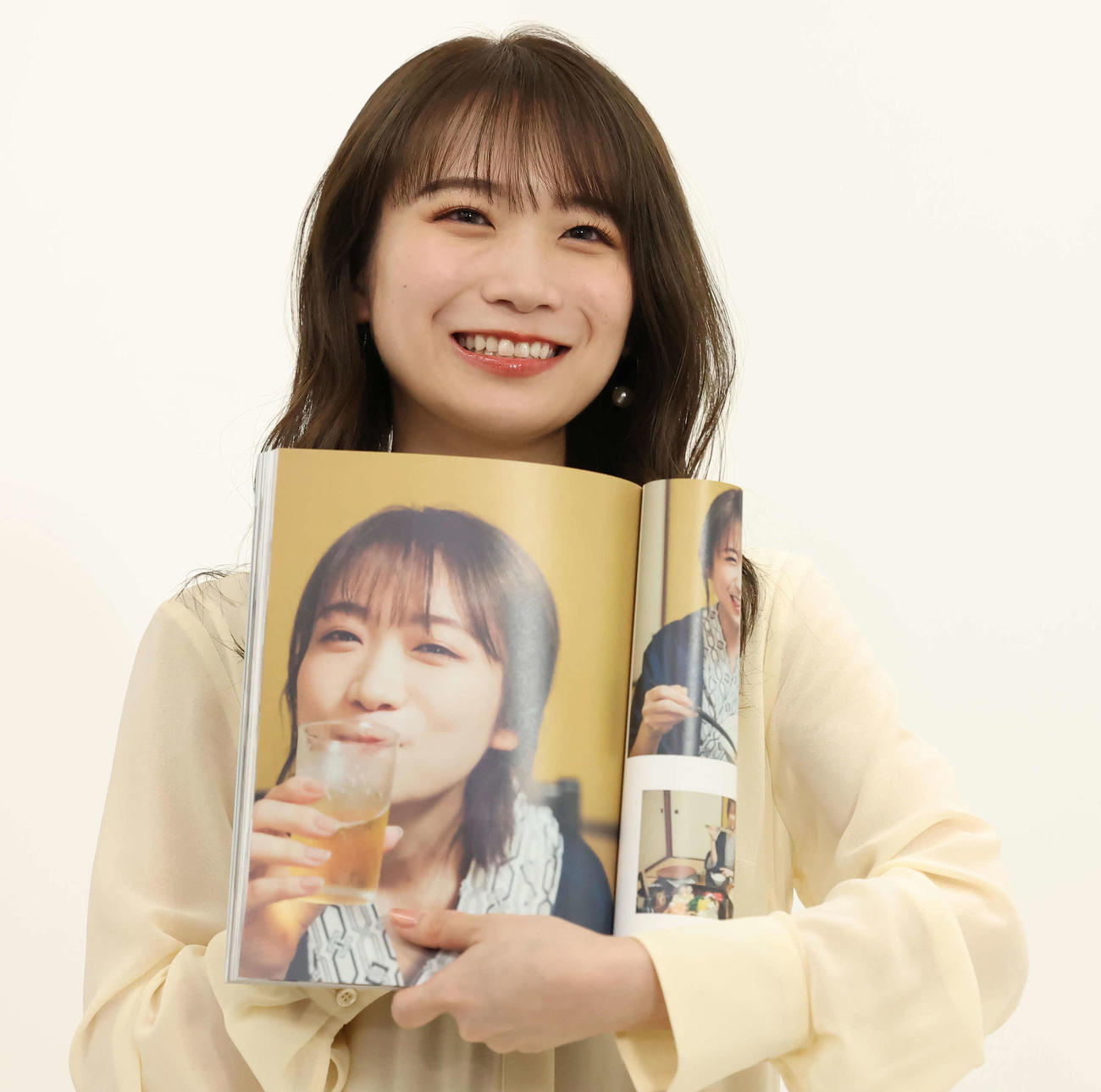 お気に入りのカットを示す秋元真夏（撮影・丹羽敏通）
