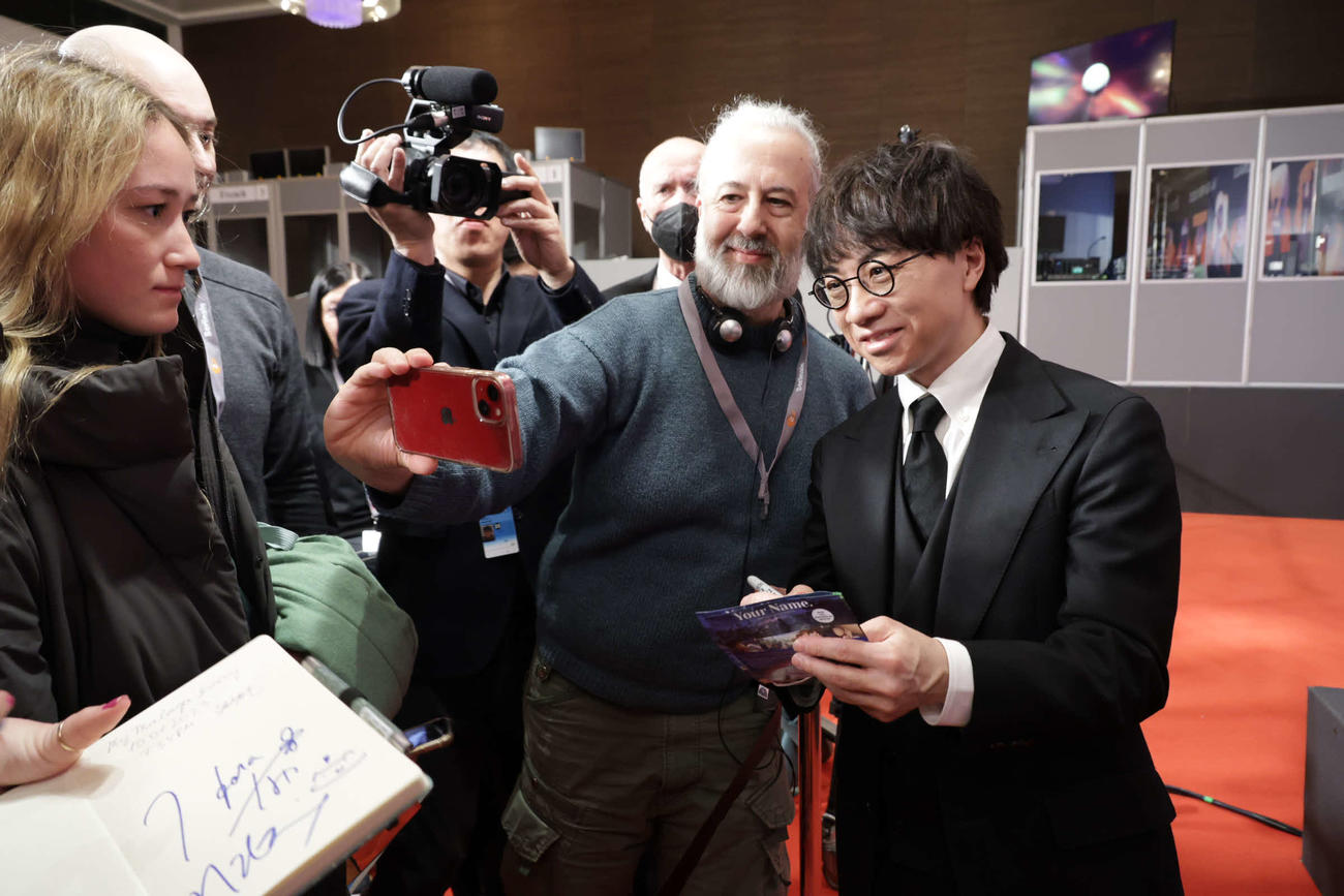 ベルリン映画祭公式会見後、ツーショット撮影を求められる新海誠監督