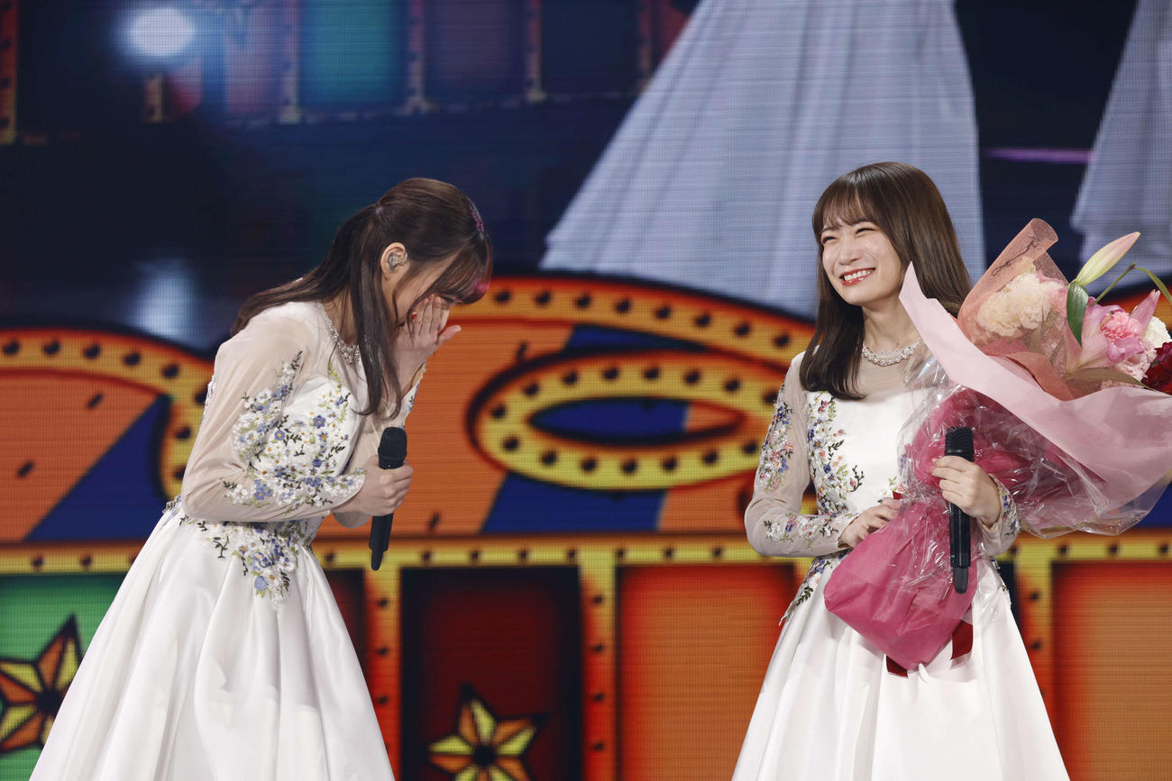 鈴木絢音に花束を渡され、泣き笑いの秋元真夏（右）
