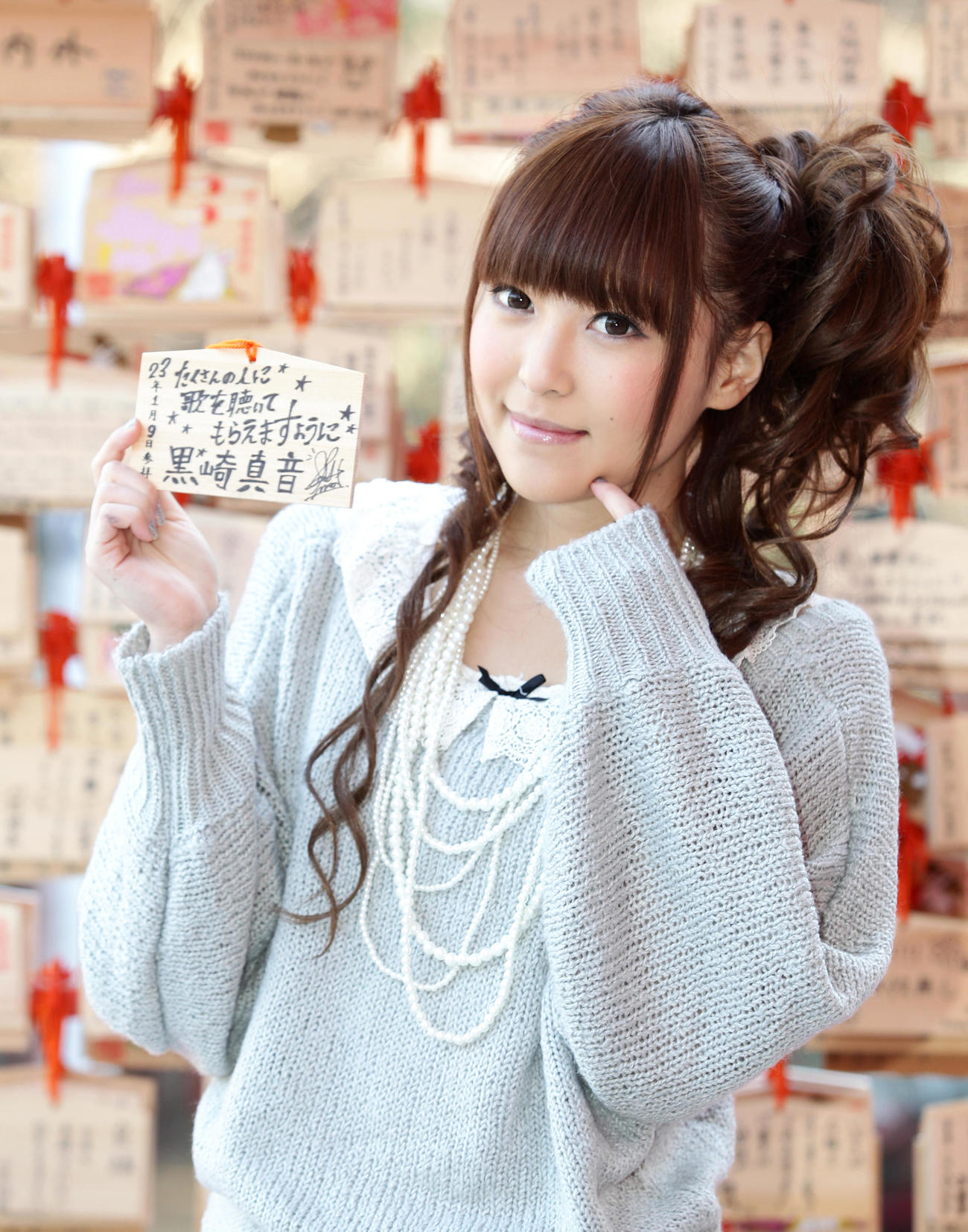 2011年1月、絵馬を手に笑顔を見せる黒崎真音さん