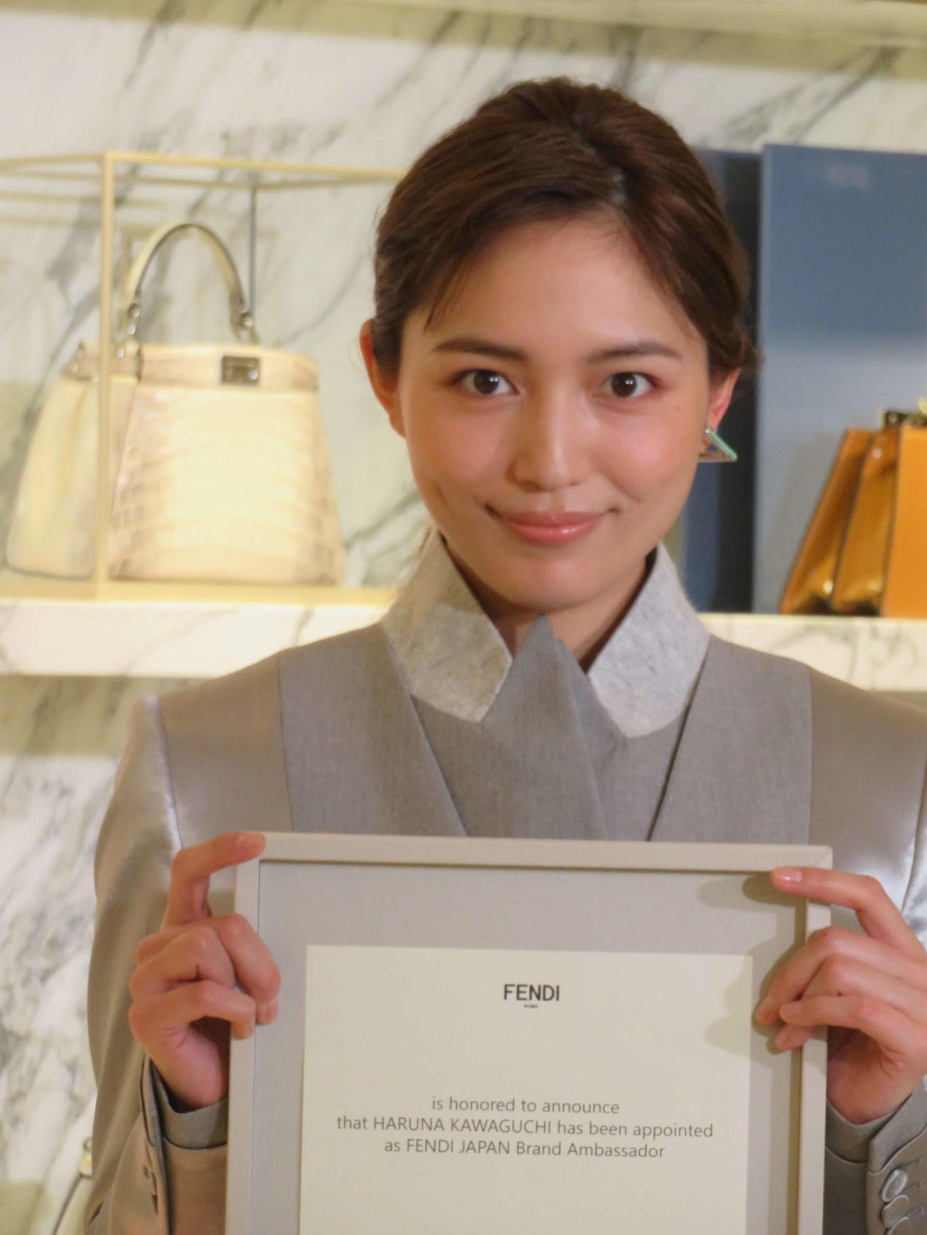 FENDIジャパンブランドアンバサダーに就任し、サインした契約書を手に笑顔の川口春奈（撮影・村上幸将）
