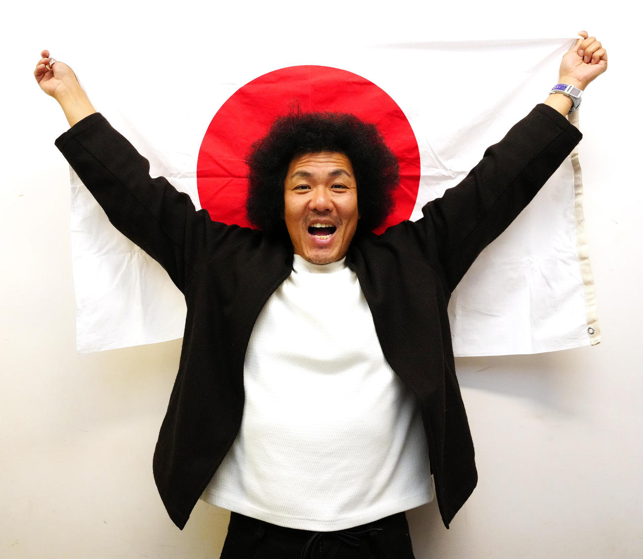 日の丸を掲げ、侍ジャパンにエールを送るトータルテンボスの藤田憲右（撮影・江口和貴）