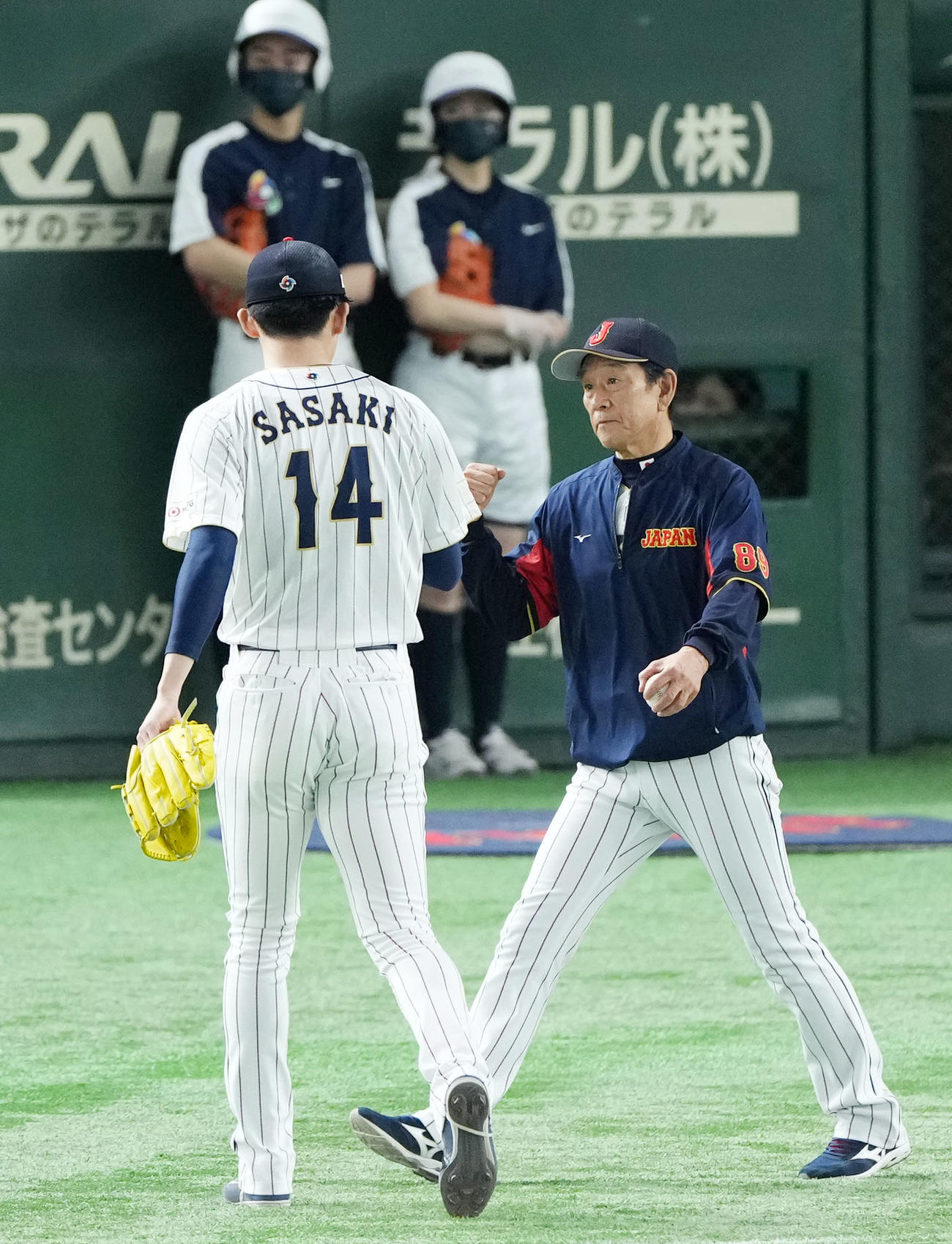 日本対チェコ　4回表途中でマウンドを降りる佐々木朗（左）とタッチを交わす栗山監督（撮影・横山健太）