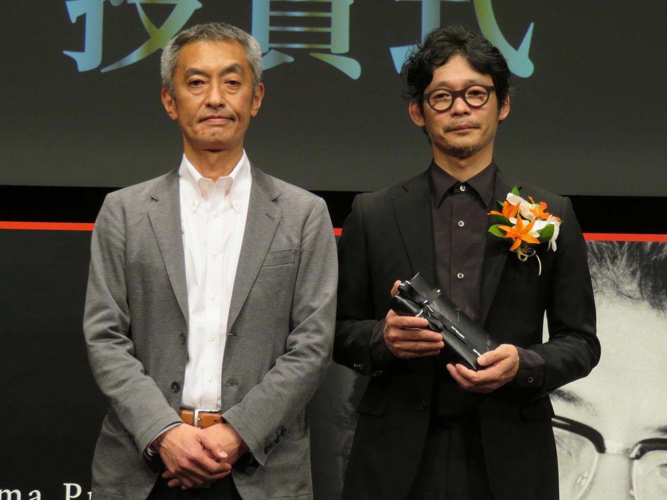 第4回大島渚賞の授賞式で記念品を山崎樹一郎監督（右）に贈呈した大島新氏