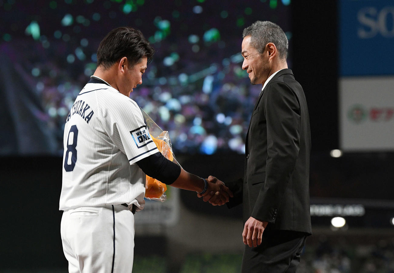 西武松坂（左）は引退セレモニーでサプライズ登場したイチロー氏から花束を受け取り握手を交わす（2021年12月撮影）