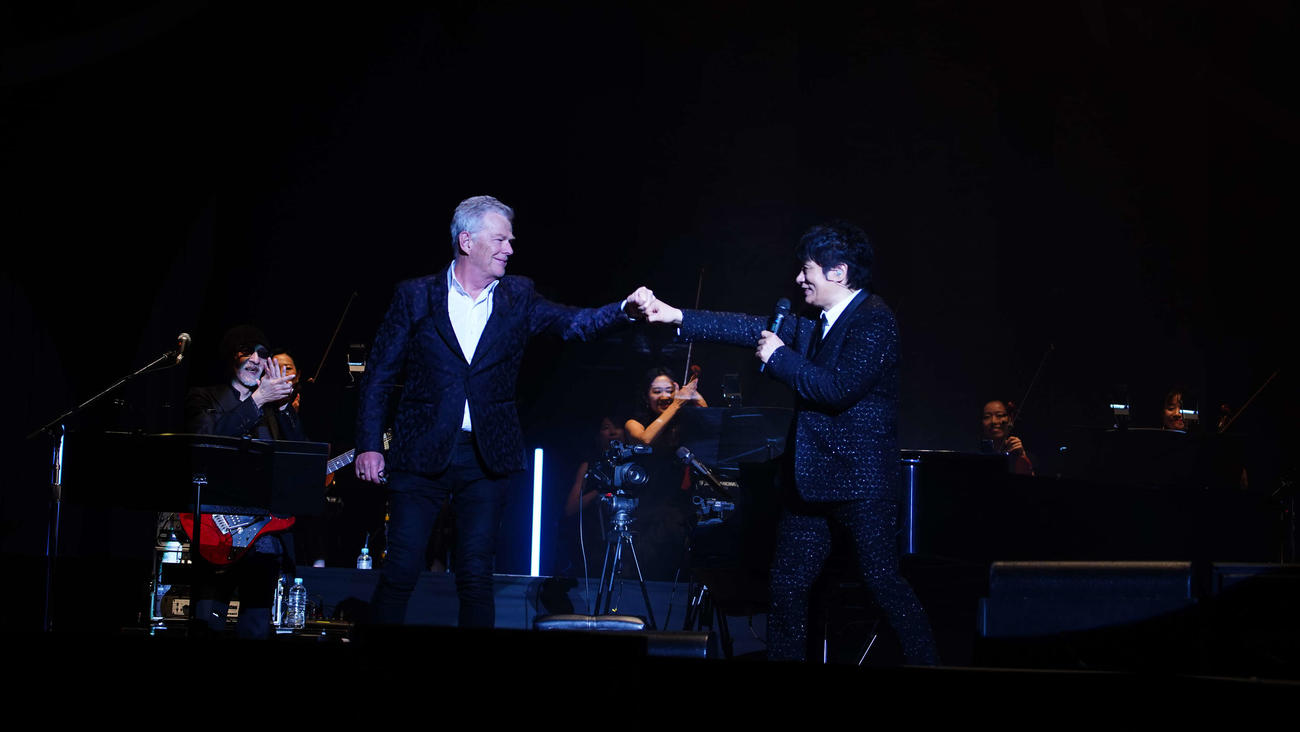 ステージ上で拳をかわすデビッド・フォスター（左）とASKA