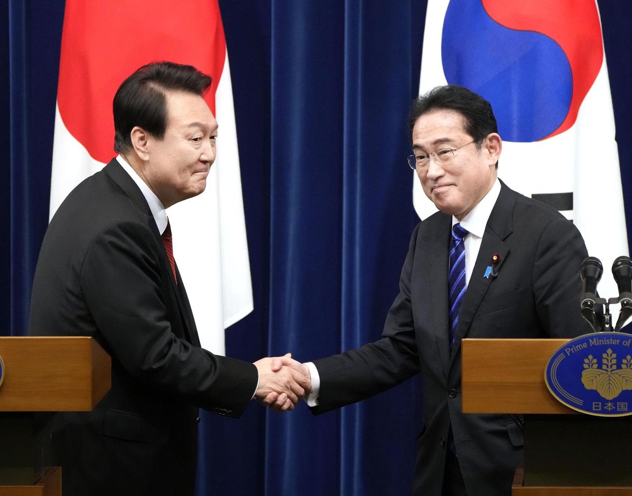 16日午後、共同記者会見で韓国の尹錫悦大統領（左）と握手する岸田首相（共同）