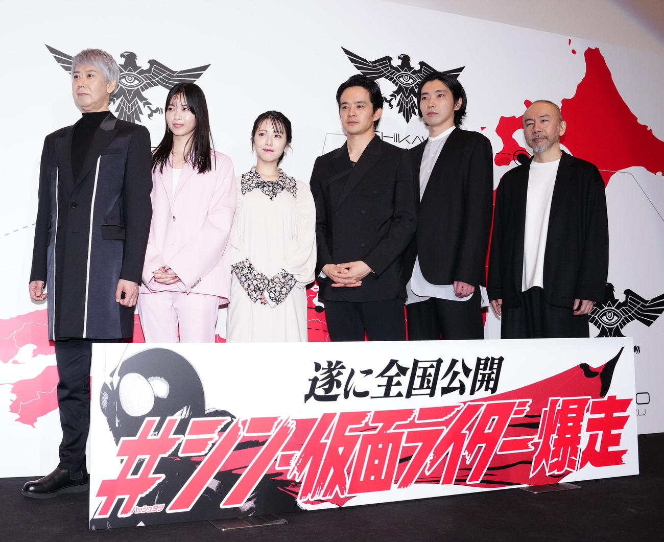 映画「シン・仮面ライダー」全国最速公開記念舞台あいさつで写真に納まる池松壮亮（左から4人目）ら出演者。左から手塚とおる、西野七瀬、浜辺美波、1人おいて柄本佑、塚本晋也（撮影・江口和貴）