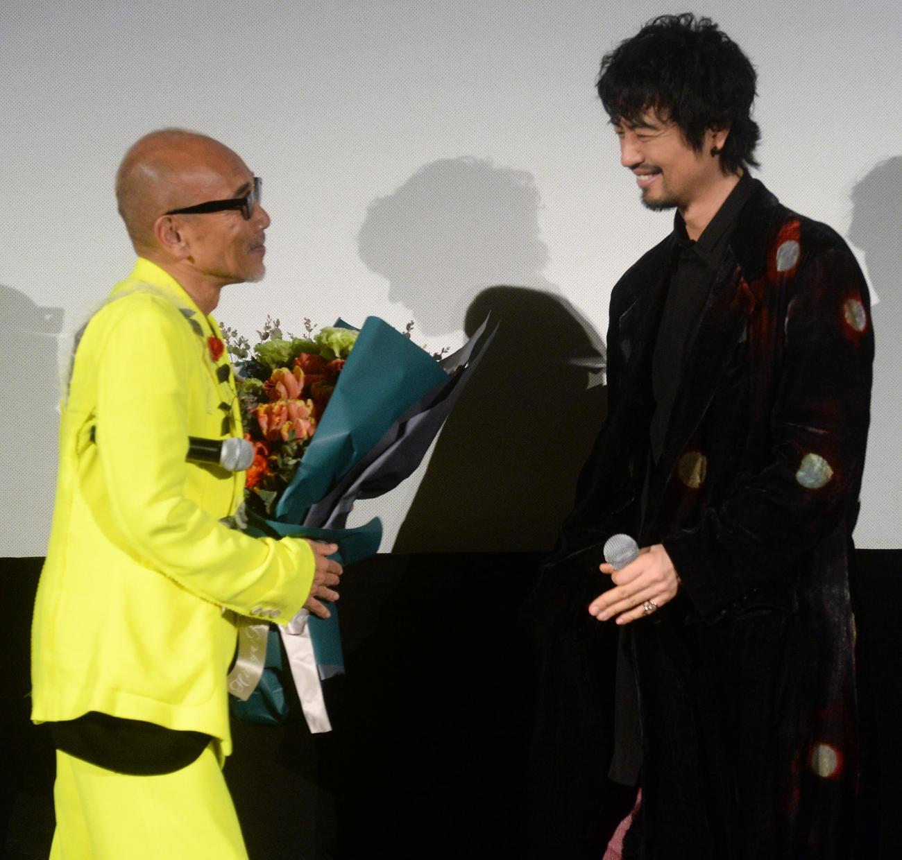 映画「雫落」公開記念舞台あいさつに登壇し、サプライズで斎藤工（右）から花束をプレゼントされる竹中直人監督