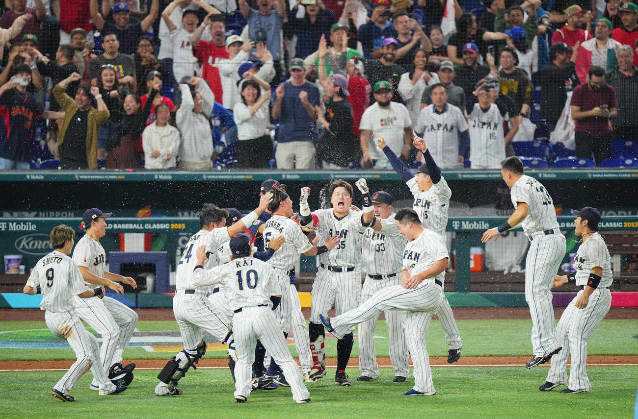 日本対メキシコ　9回裏日本無死一塁、サヨナラ適時二塁打を放った村上（中央）はチームメートの祝福を受けながら歓喜のガッツポーズ（撮影・垰建太）