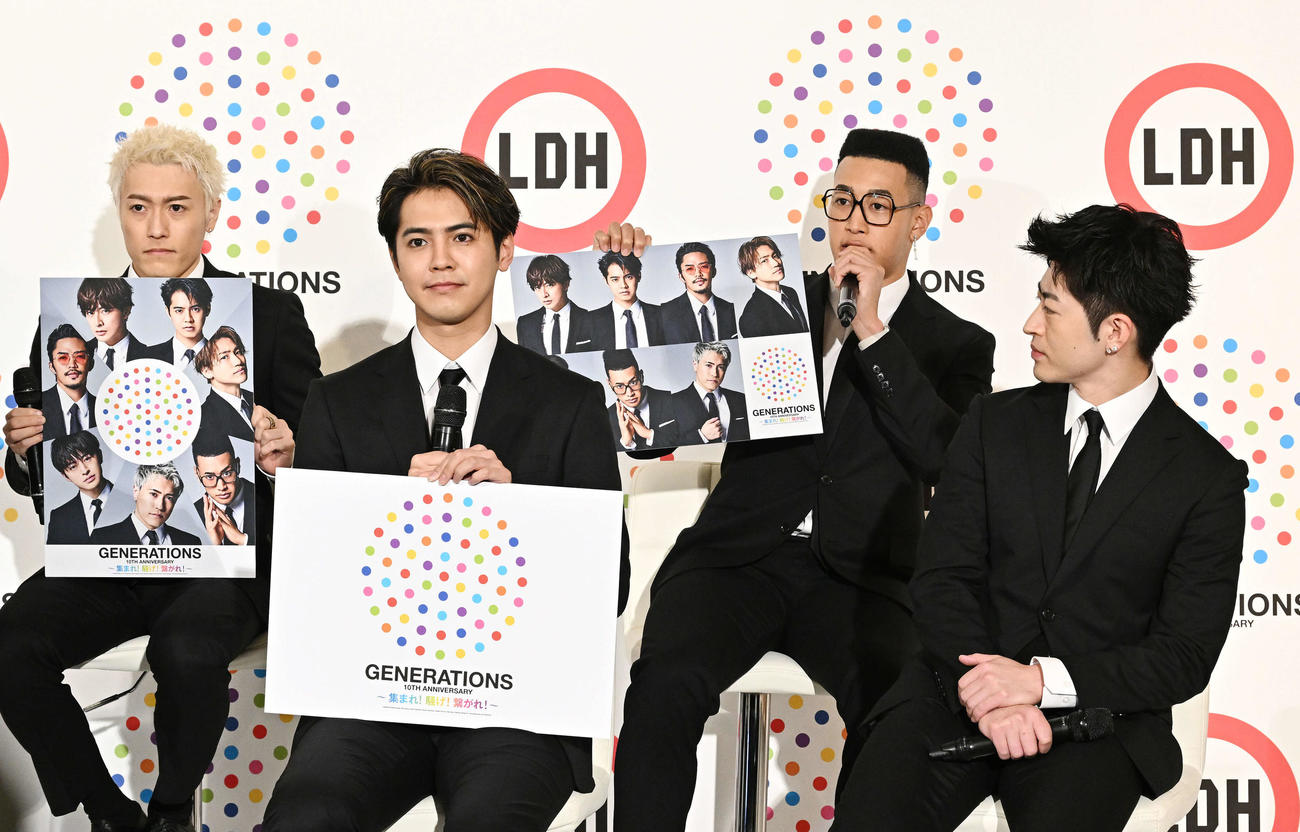 10周年のロゴ入りの写真を手にするGENERATIONSの中務裕太（左）と関口メンディー（左から3人目）。左から2人目は片寄涼太と佐野玲於（撮影・滝沢徹郎）