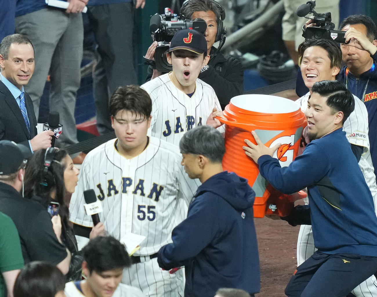 日本対メキシコ　ヒーローインタビューを受ける村上（手前）にスポーツドリンクを持ち近づく佐々木（後方）と山本（後方右）（撮影・菅敏）