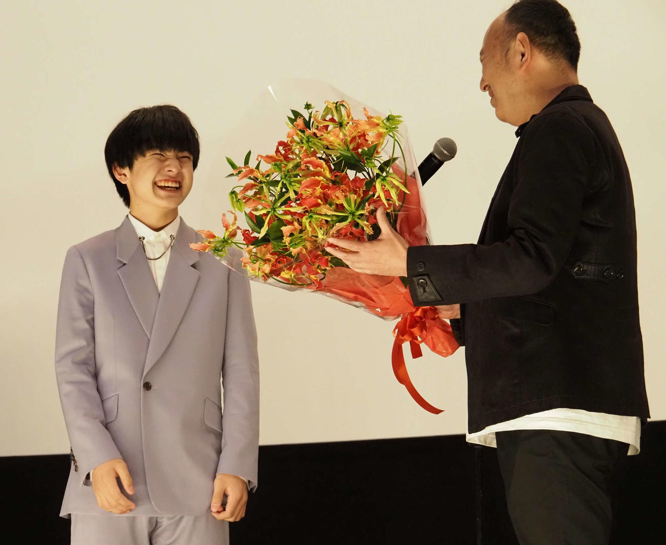 足立紳監督から花束を渡され、笑顔を見せる池川侑希弥（左）（撮影・遠藤尚子）