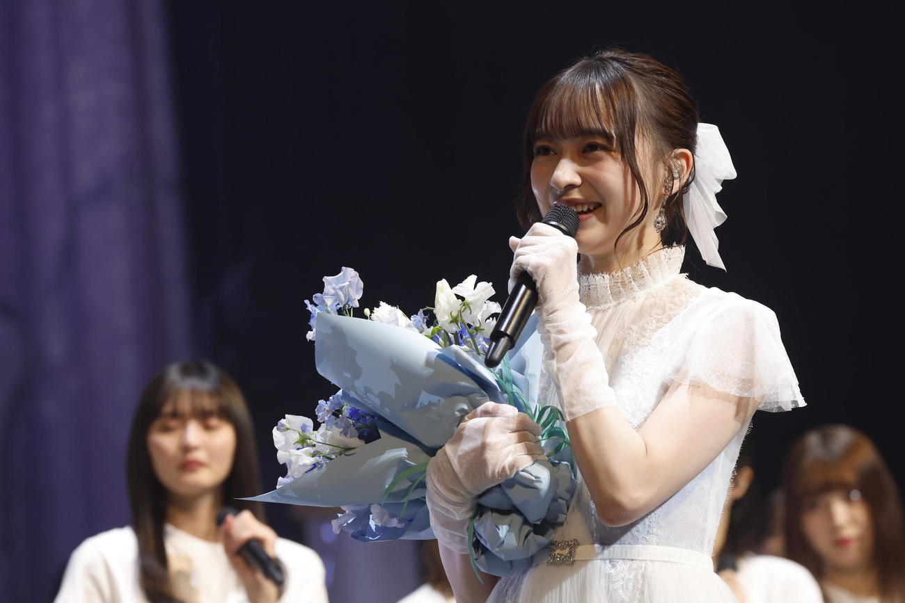 卒業セレモニーでサプライズ登場した2期生たちから花束を渡され笑顔を見せる乃木坂46鈴木絢音