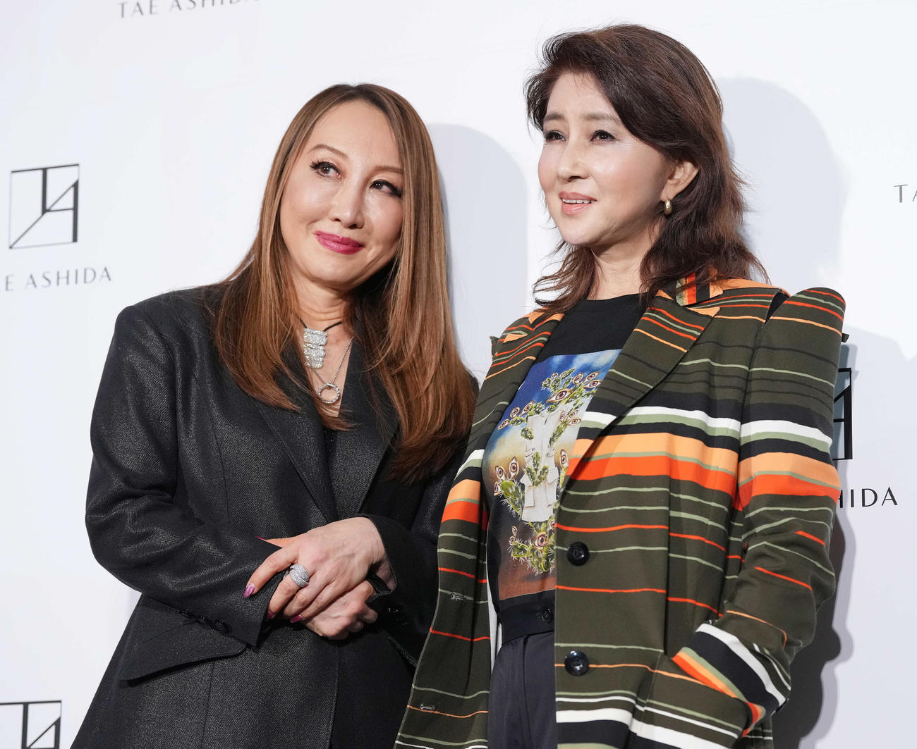 「TAE ASHIDA AUTUMN WINTER COLLECTION 2023－2024」を観覧した後、芦田多恵氏（左）と記念撮影する秋吉久美子（撮影・鈴木みどり）