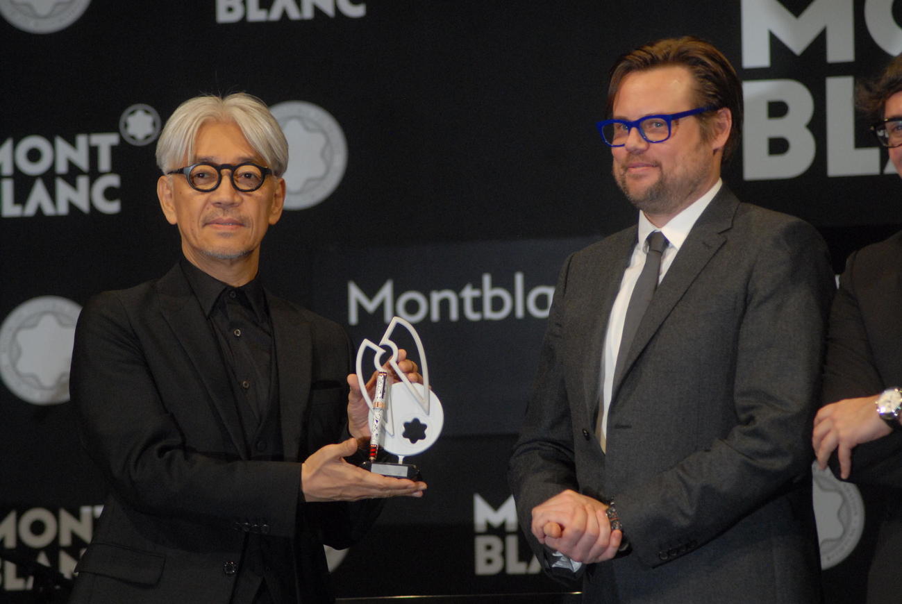 「第25回モンブラン国際文化賞」を受賞しトロフィーを受け取る坂本龍一さん（左）（2016年12月撮影）