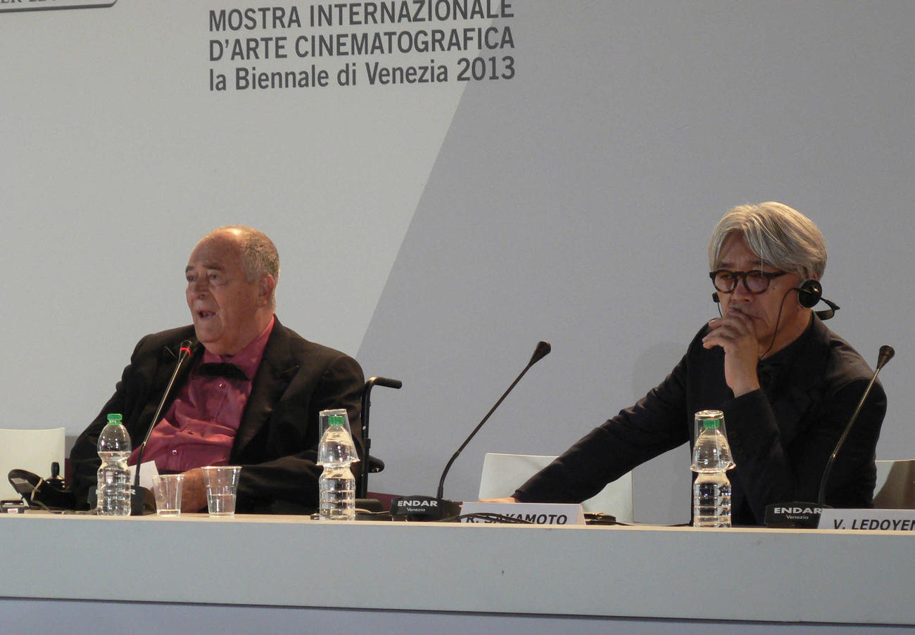 ベネチア映画祭の授賞式後、審査員長のベルナルド・ベルトルッチ監督（左）と並んで会見に出席した坂本龍一（2013年9月撮影）