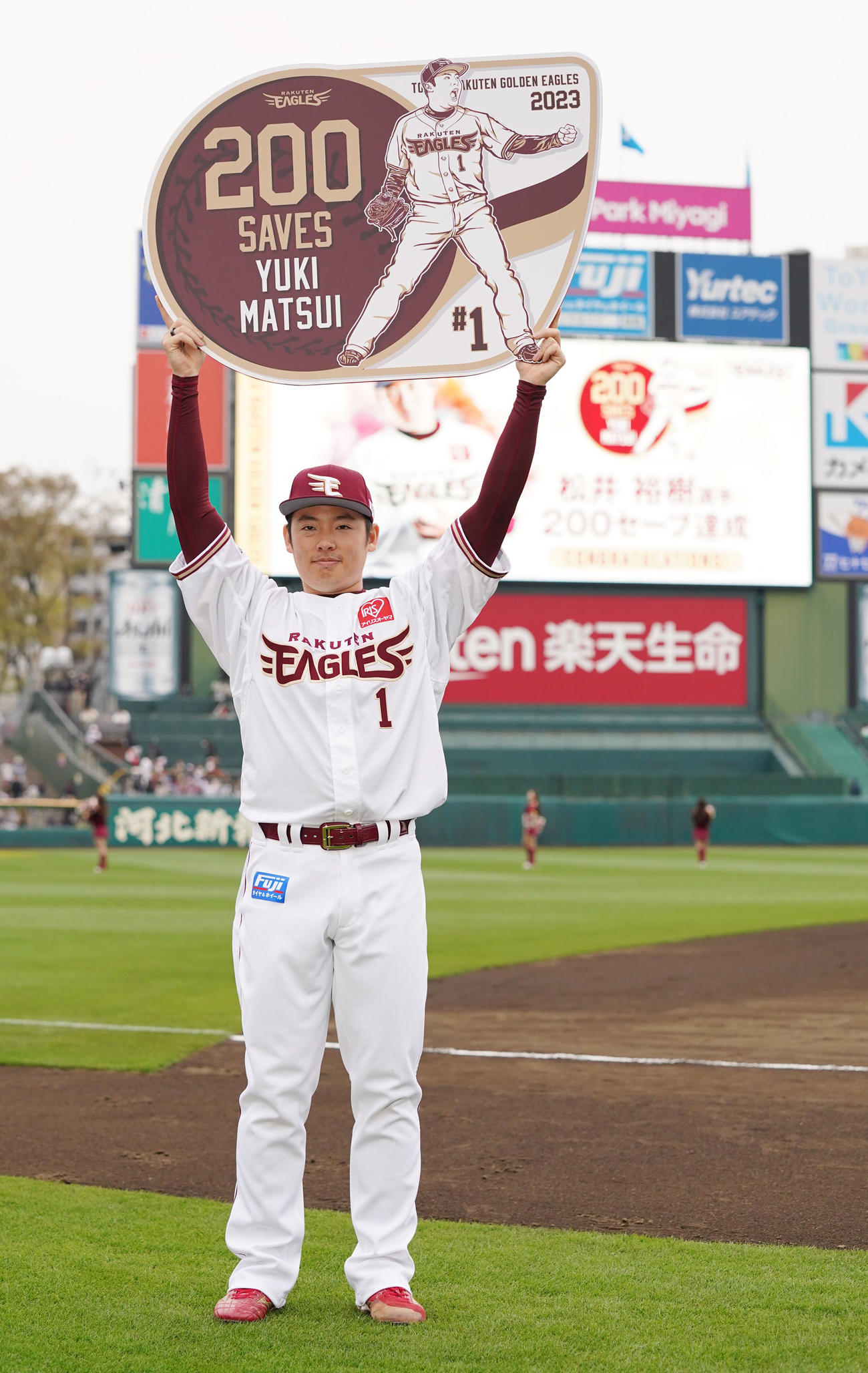 楽天対西武　史上最速でプロ入り通算200セーブを挙げた楽天松井裕は記念のボードを高々と掲げる（撮影・小沢裕）