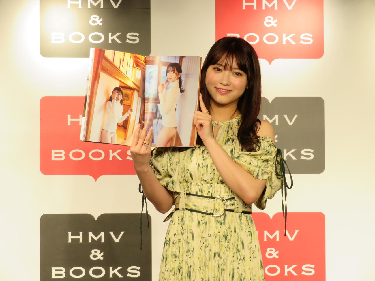 自身初の写真集「体感温度」の発売記念イベントで、お気に入りのページを見せる古田愛理