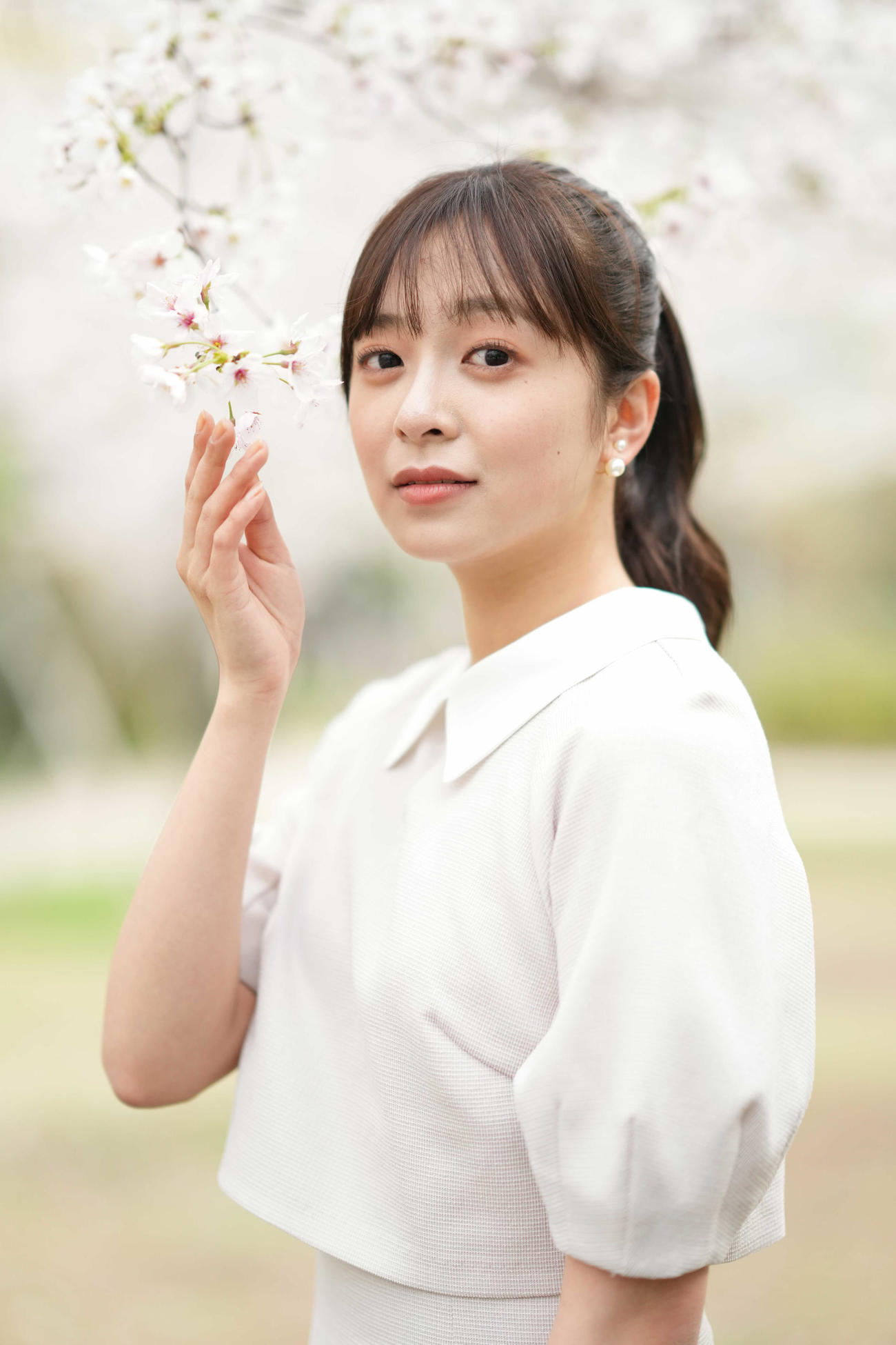 満開の桜の下、カメラを見つめる菊池柚花（2023年3月撮影）