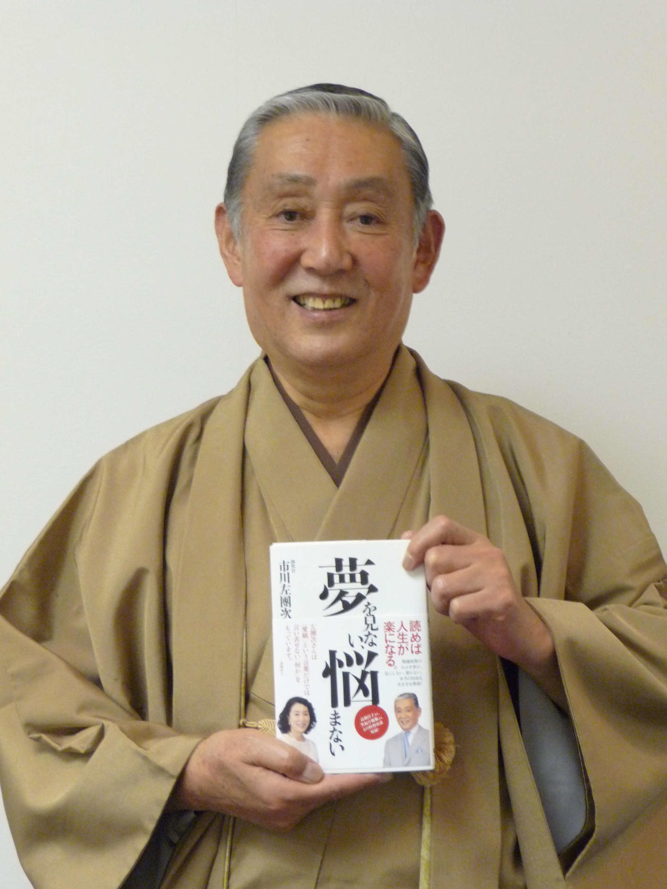 著書「夢を見ない、悩まない」を手にした市川左團次さん（2014年12月撮影）