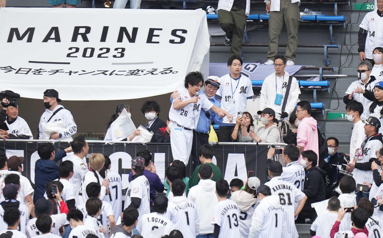 ロッテ対楽天　試合前、右翼席のファンと一緒に盛り上がっていたぺこぱの松陰寺太勇（中央）は、セレモニアルピッチに間に合わなくなるため警備員に連行される（撮影・鈴木みどり）