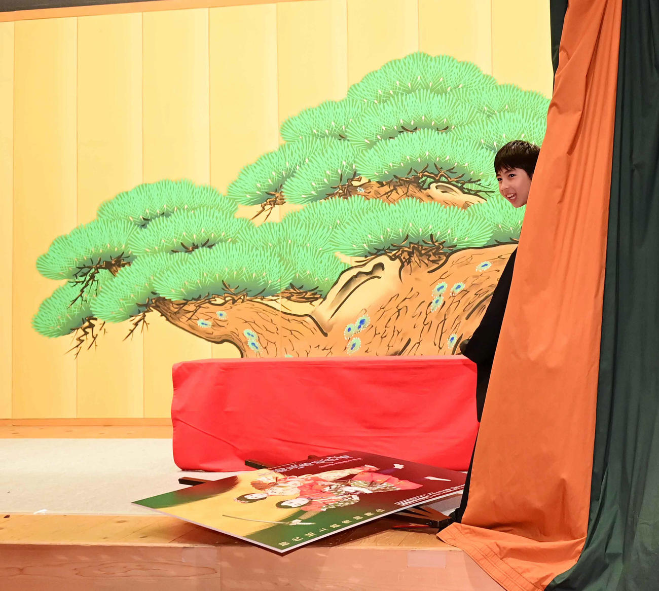 関係者から促されて舞台の幕を開けた初代尾上眞秀だったがポスターの看板を倒してしまい笑顔を見せる（撮影・小沢裕）