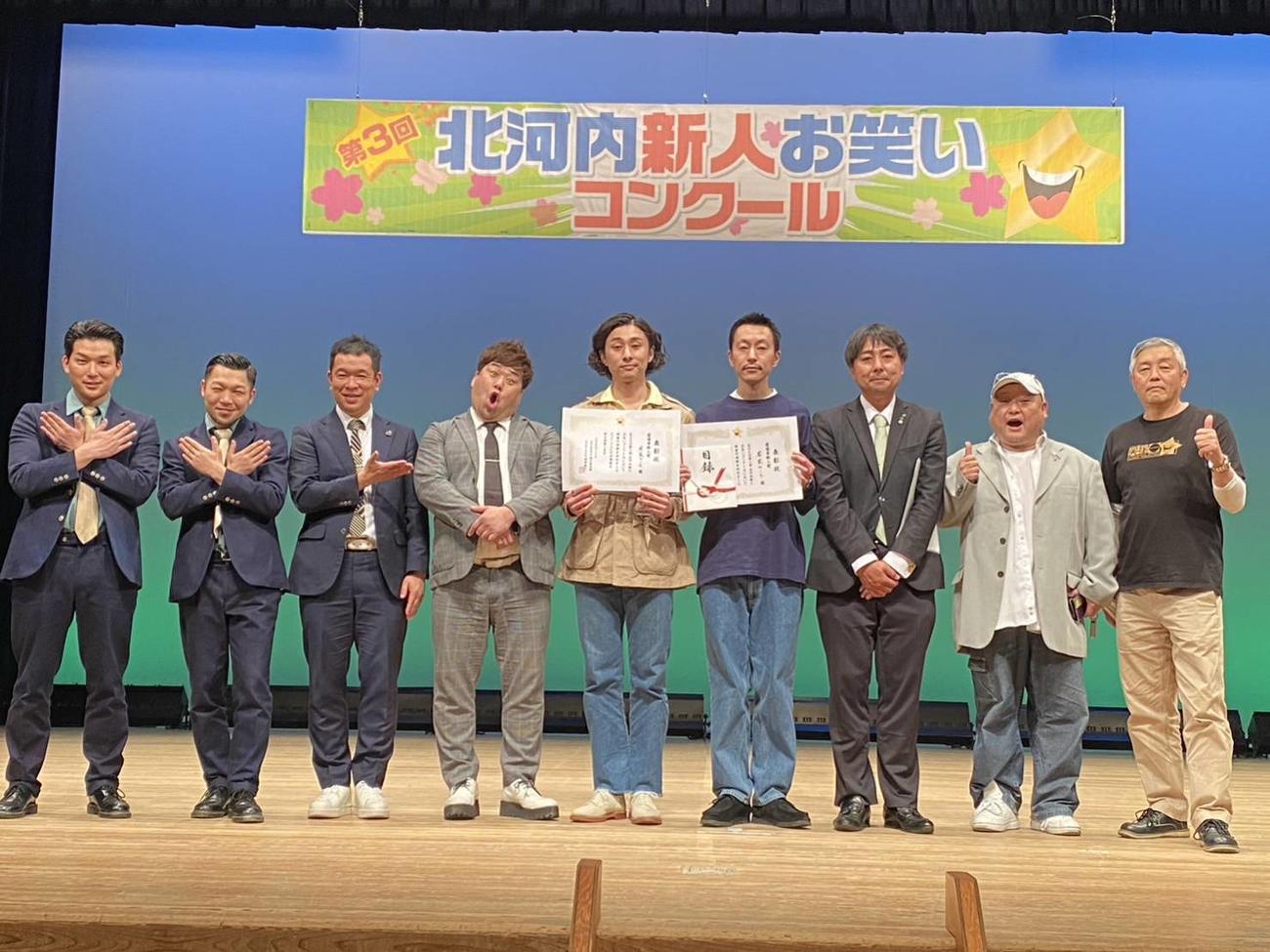 「第3回北河内新人お笑いコンクール」の優勝の若葉のころ（左から5、6人目）と審査員たち