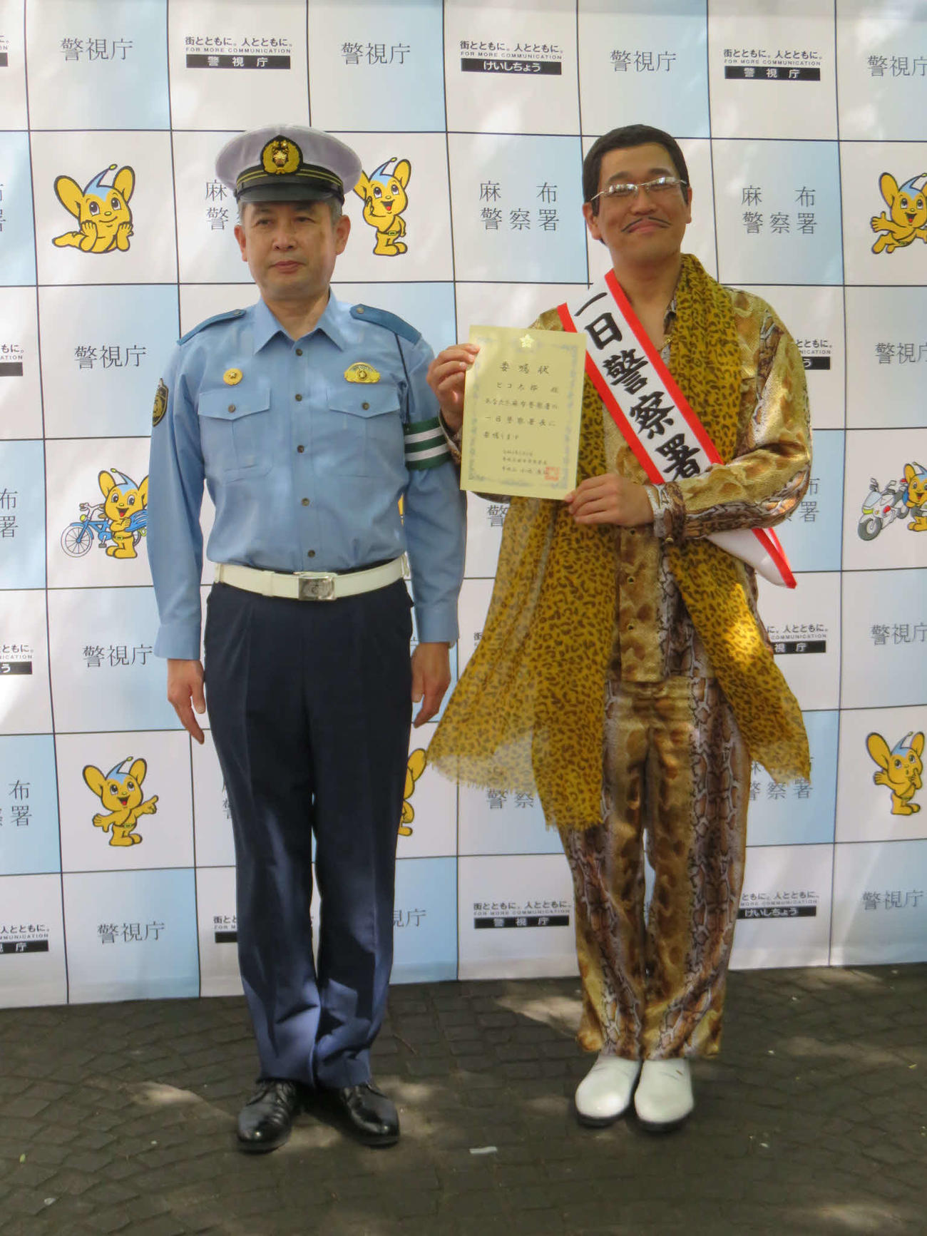 小池康弘麻布警察署長（左）から一日警察署長を委嘱されたピコ太郎