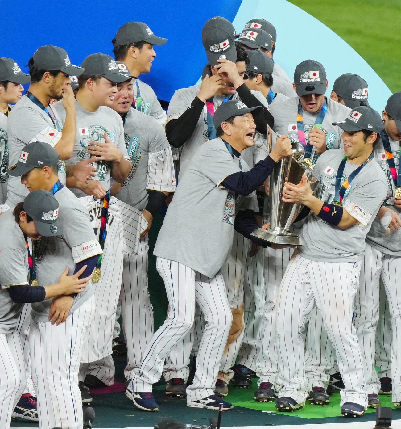 WBC日本対米国　優勝セレモニーでトロフィーを重たそうに持つ栗山監督。右はそれを支える近藤（2023年3月21日撮影）