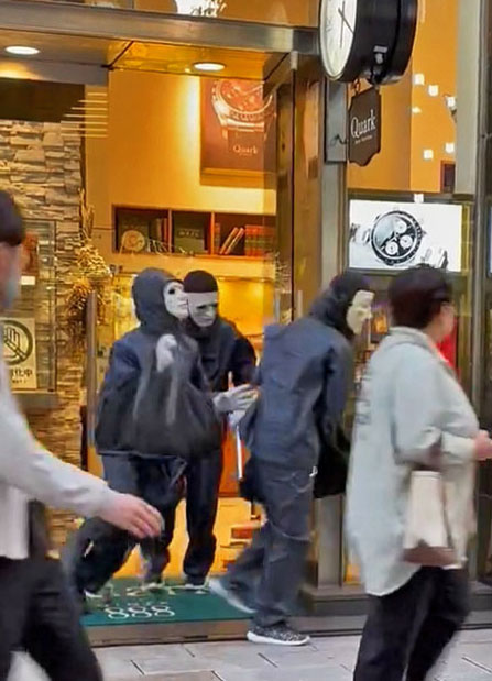 8日、強盗事件があった東京・銀座のロレックス専門店から逃走する仮面姿の3人（目撃者提供＝共同）