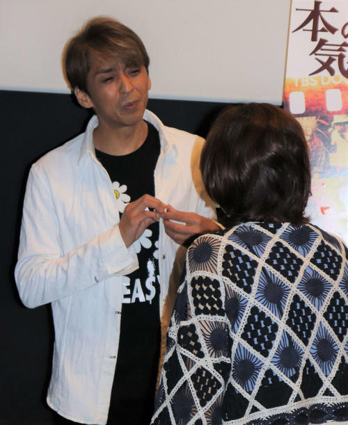 SMAP5名のメンバーカラーをあしらったピンバッジについてファンと話す森且行。今年2月に森のスポンサーが発売し舞台あいさつ当日に森も身につけた（撮影・中島麗）